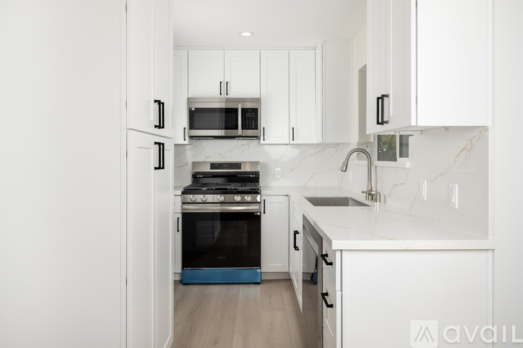 A modern kitchen with white cabinets and appliances.