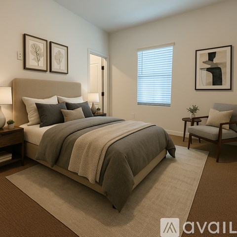 A bedroom with a large bed and a chair.