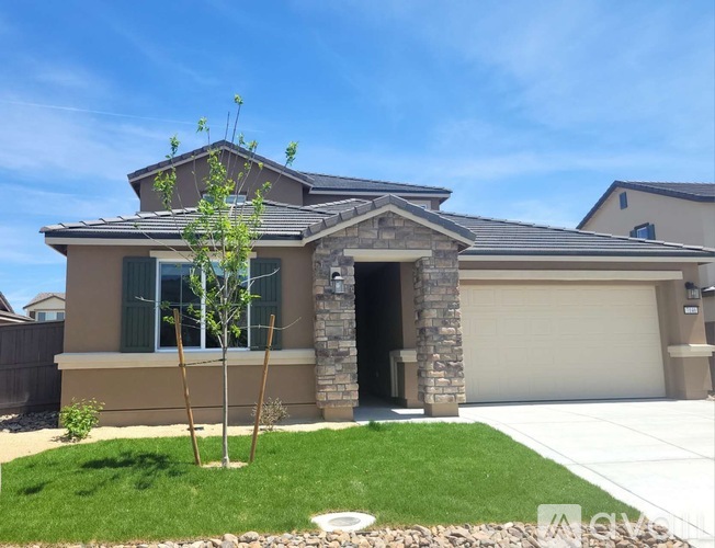 A house with a brown roof and a grey garage door.
