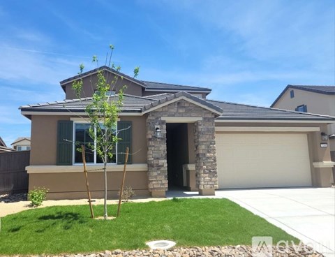 A house with a brown roof and a grey garage door.