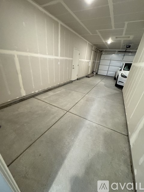 A spacious garage with a white car parked inside.