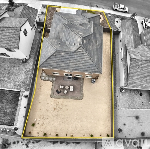 A bird's eye view of a property with a large grey building and a yellow line around it.