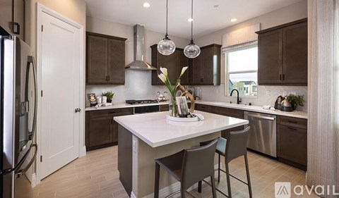 A modern kitchen with a white island and dark brown cabinets.