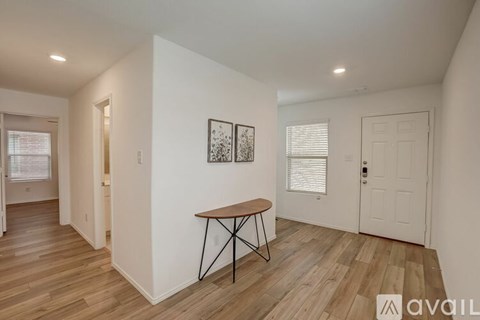 A room with a wooden floor and a table with a metal base.