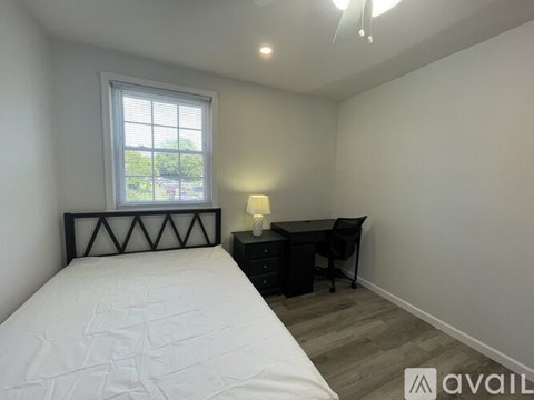 A bedroom with a bed, desk, and chair.