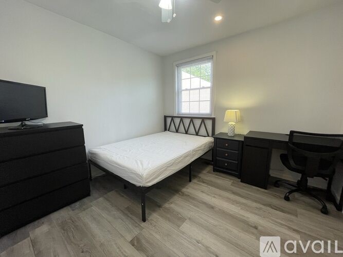 A bedroom with a bed, desk, and chair.