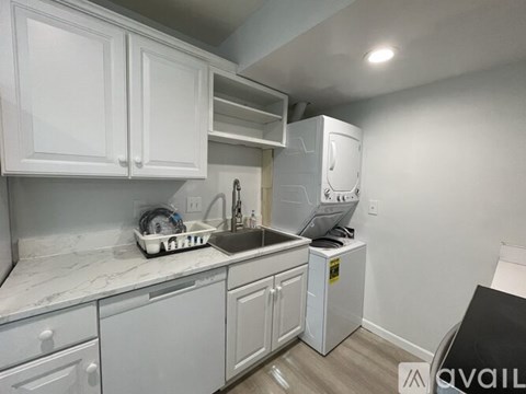 A kitchen with white cabinets and a marble countertop.