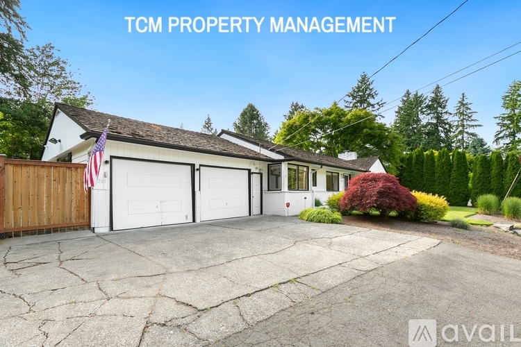 A house with a garage and a flag on the wall is for sale.