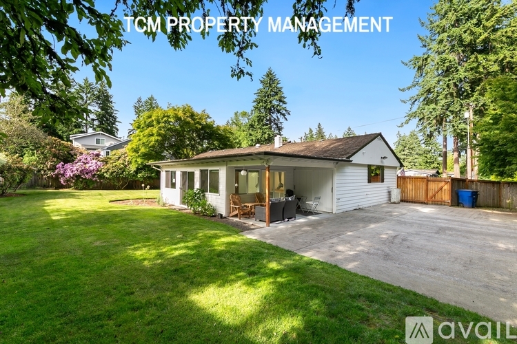 A house with a lawn and trees is for sale.