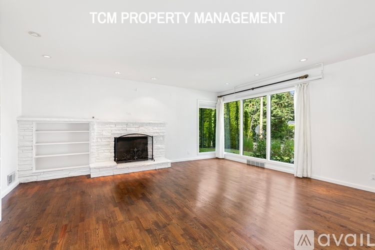 A spacious room with a fireplace and wood flooring is available for rent.