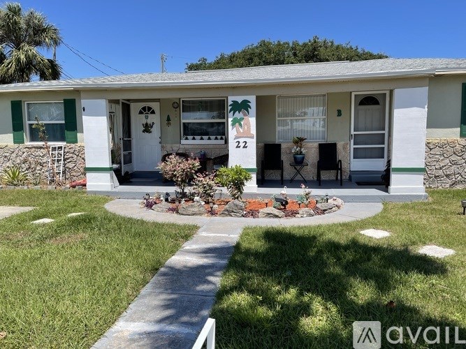 A house numbered 22 with a white door and green trim.