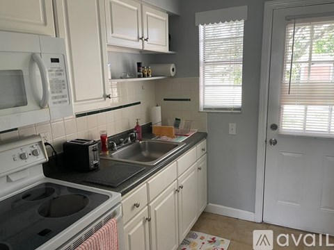 A kitchen with white cabinets and a black stove top.