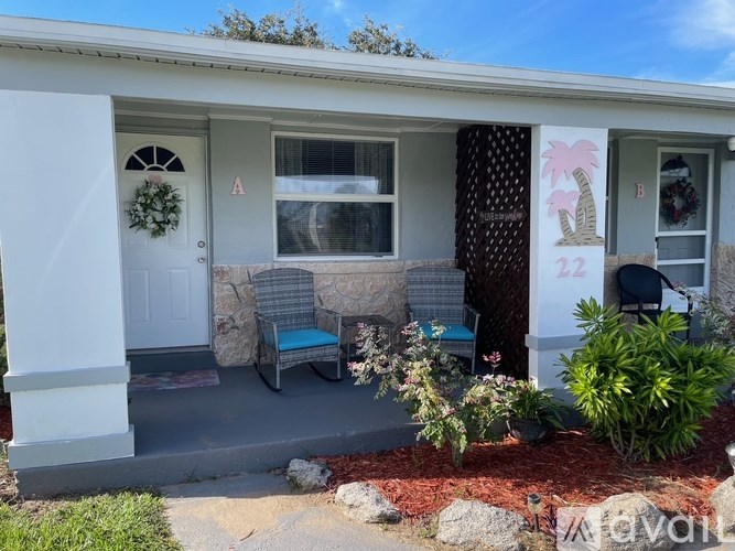 A small house with a white door and a wreath on it.