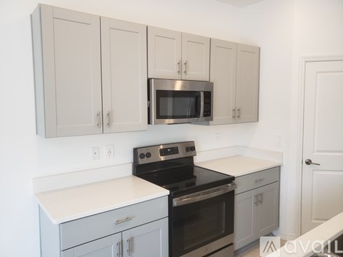 A kitchen with a black stove and white countertops.