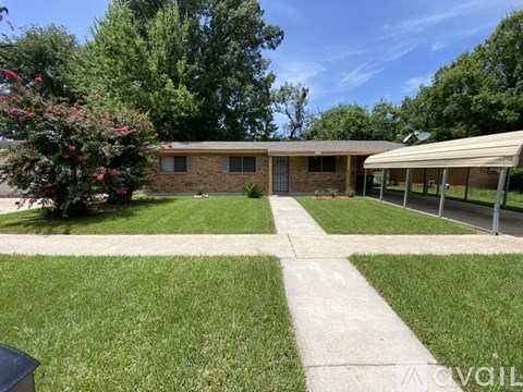 A house with a green lawn and a concrete pathway leading to the front door.