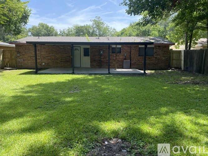 A small brick house with a green lawn in front.