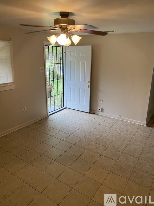 A room with a ceiling fan and a door leading outside.