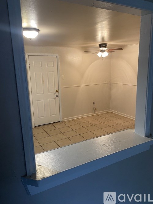 A room with a white door and a ceiling fan.