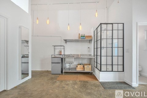 A kitchen area with a glass cabinet and a countertop with a sink.