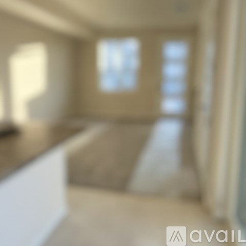 A blurry image of a kitchen with a counter and a window.