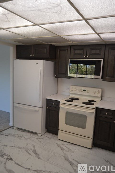 A kitchen with a white fridge and a white stove top oven.