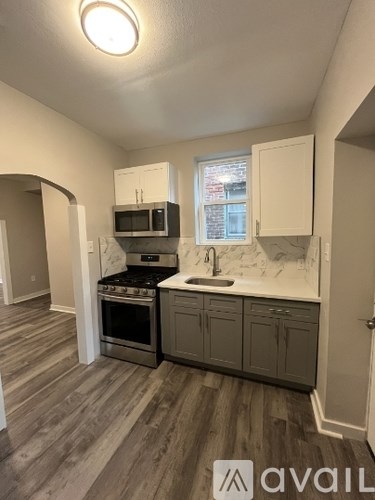A kitchen with a stove top oven, microwave, and sink.