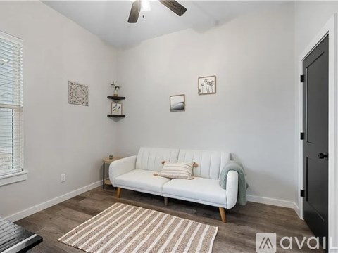 A living room with a white couch and a rug.