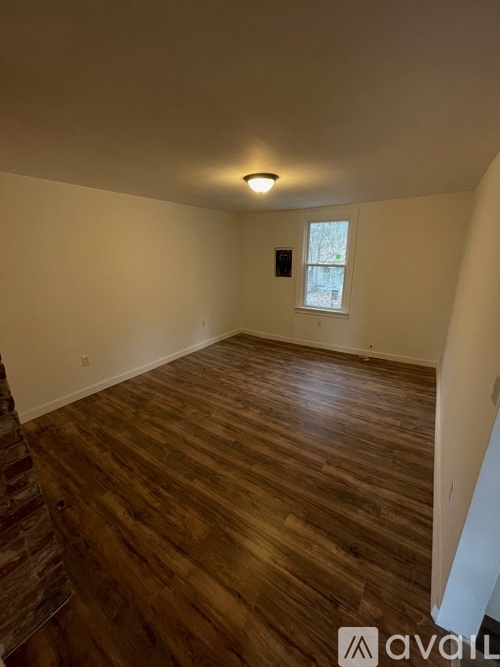 A room with wooden flooring and a window.
