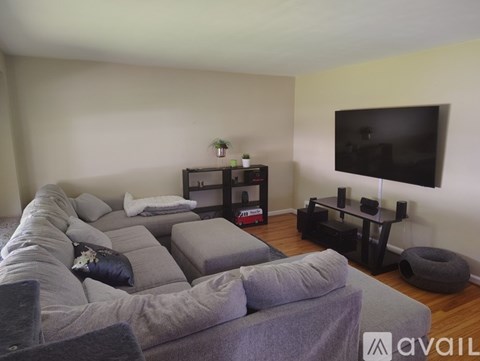 A living room with a grey couch and a black TV.