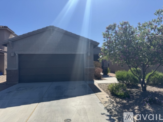 A house with a garage and a tree in front.