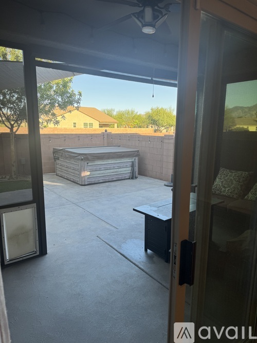 A patio with a table and chairs and a hot tub.