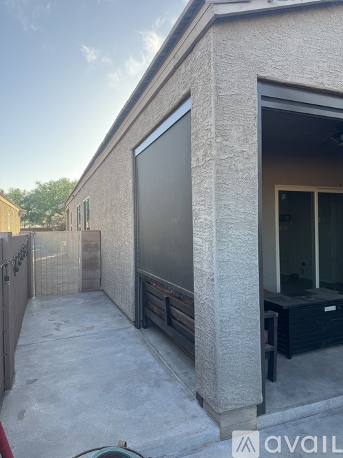 A concrete building with a black screen door and a black box outside.