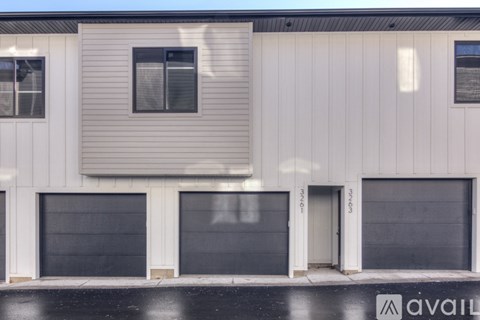 A building with three garage doors and two windows.