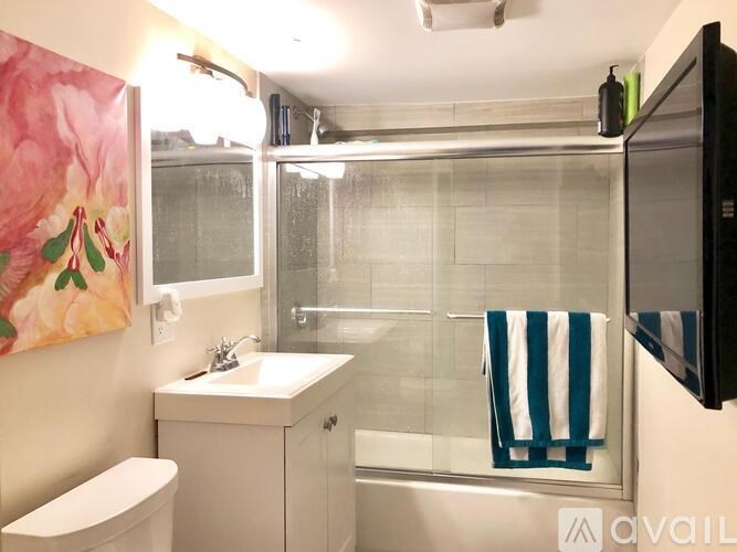 A bathroom with a toilet, sink, and shower.