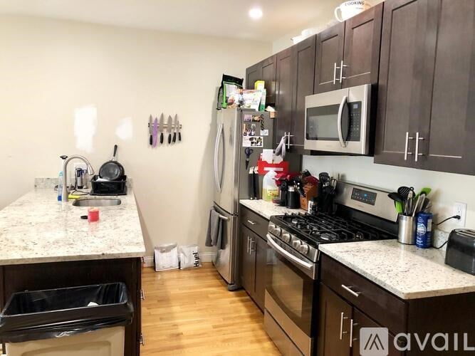 A kitchen with brown cabinets and a granite countertop.