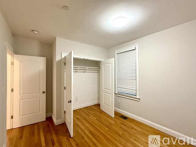 A white door with a glass panel is in the middle of a hallway.