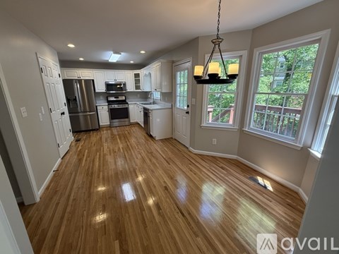 A spacious kitchen with wooden floors and a large island.