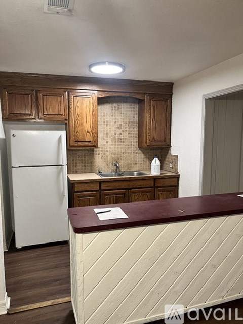 A kitchen with wooden cabinets and a white refrigerator.