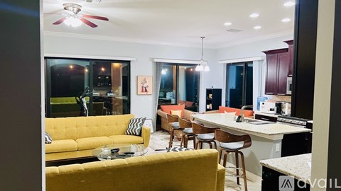 A brightly lit living room with a yellow couch and a bar area.