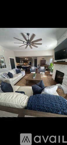 A living room with a white couch and a ceiling fan.