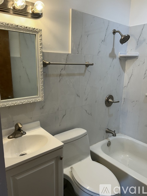 A bathroom with a marble wall and a white toilet.