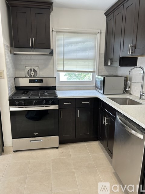 A kitchen with black cabinets and stainless steel appliances.