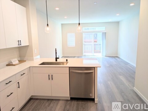 A kitchen with white cabinets and a stainless steel dishwasher.