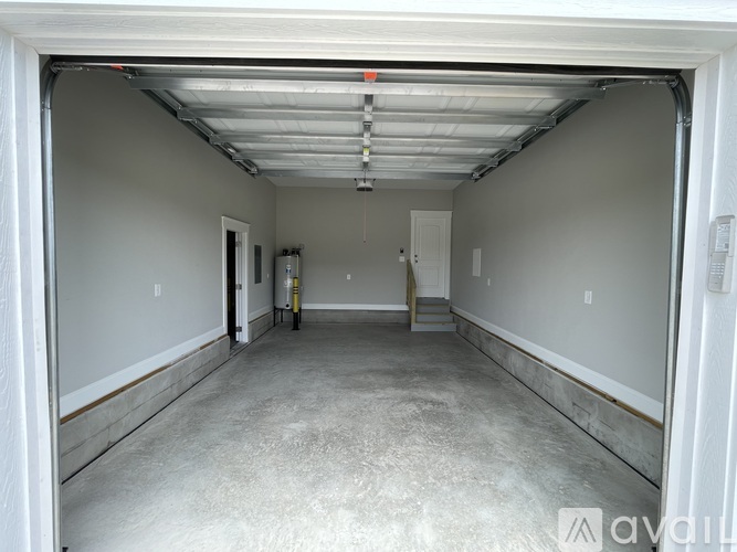 A spacious garage with a concrete floor and white walls.