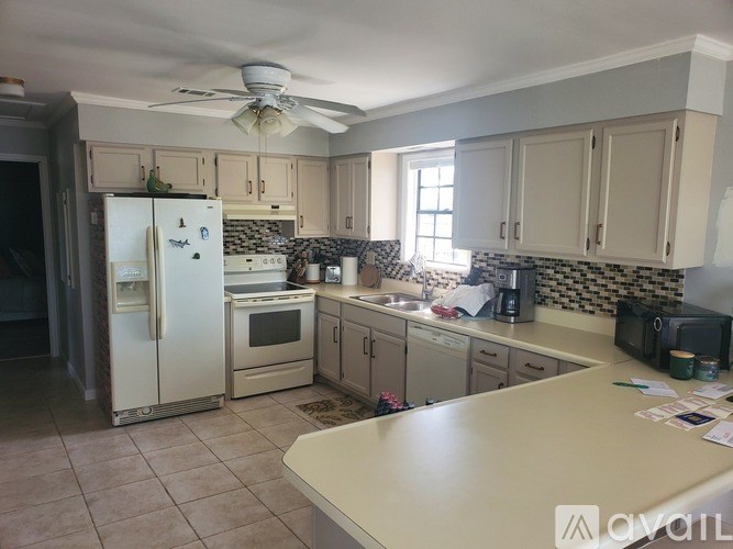 A kitchen with a refrigerator, oven, and sink.