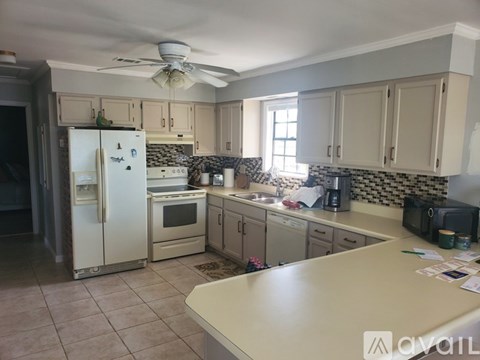 A kitchen with a refrigerator, oven, and sink.