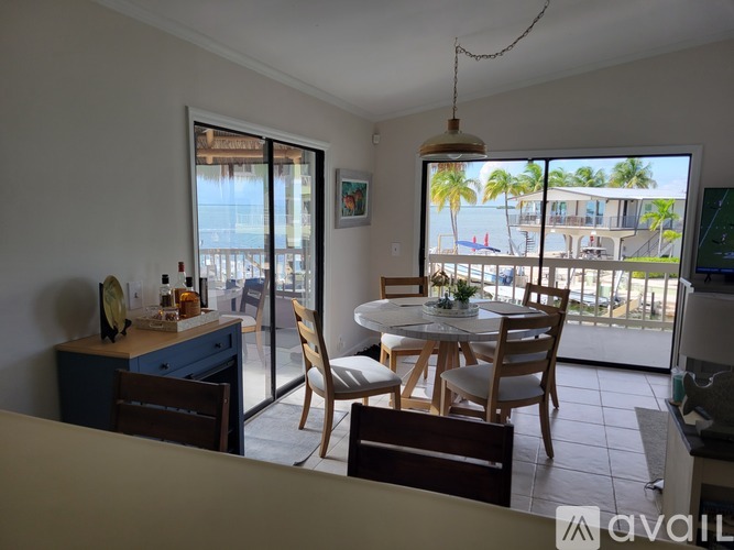 A dining room with a table set for four and a view of the beach.