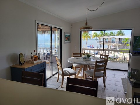 A dining room with a table set for four and a view of the beach.
