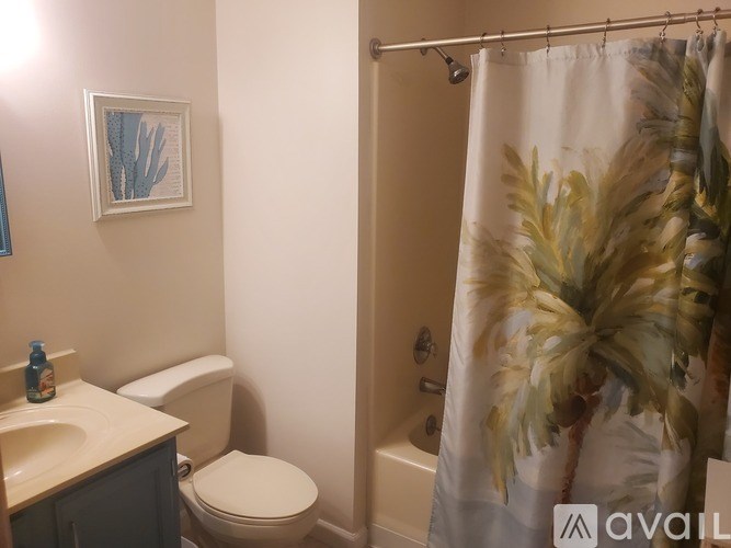 A bathroom with a toilet, sink, and shower curtain.