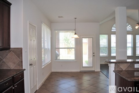 A kitchen with brown cabinets and a tiled floor.